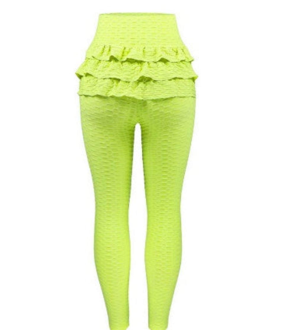 Bright neon green stretch activewear set featuring high-waisted textured leggings and a coordinating ruffled crop top or waist detail. Full-length front view showcasing the vibrant color, ruched ruffle layers, and form-fitting silhouette on a plain white background.