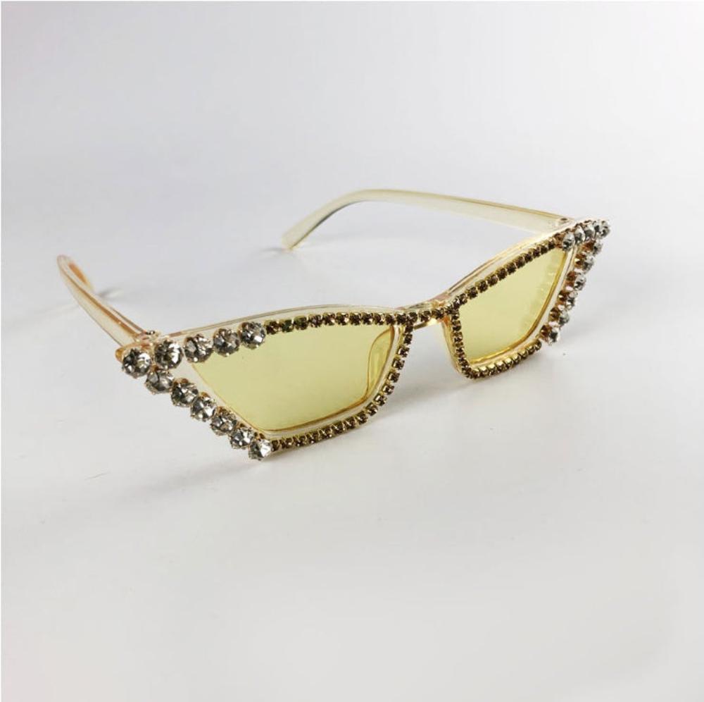 Clear yellow rhinestone cat-eye sunglasses with yellow tinted lenses and crystal trim, product photo on a white background.
