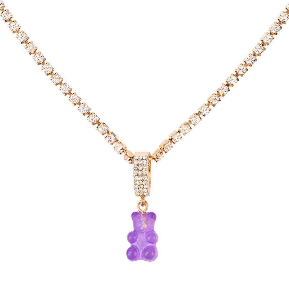 Sparkling silver tennis chain necklace featuring a fully pavé-style band and a bright purple translucent gummy bear pendant hanging from the center. Clean product photography on a plain white background.