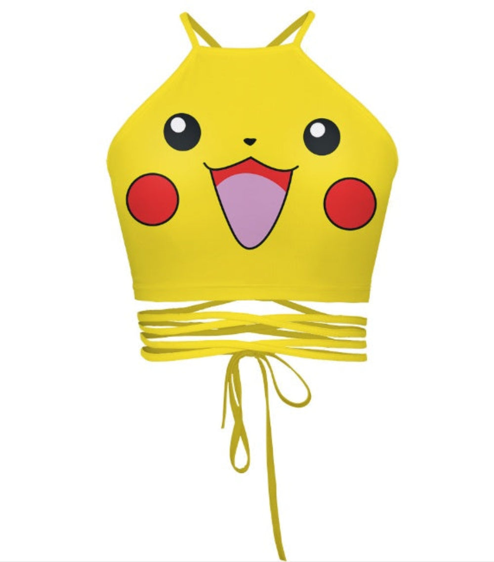 Yellow Pikachu halter crop top with face graphic print and multi-strap tie-back detail, shown flat lay on white background.