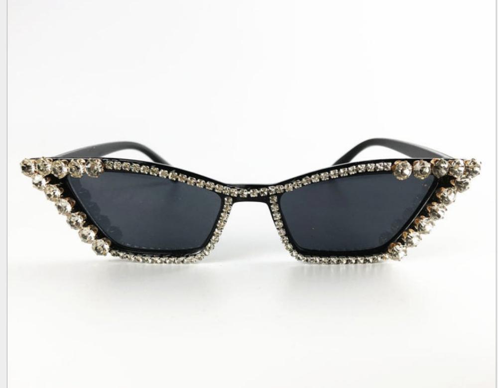 Black cat-eye sunglasses with dark lenses and crystal rhinestone trim, product photo on a white background.