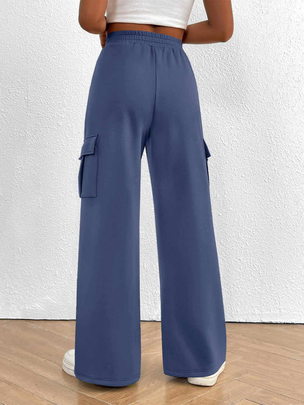 Person wearing blue cargo pants on a white background