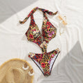 Colorful floral and leopard print bikini set on a white surface with a straw hat and sunglasses.