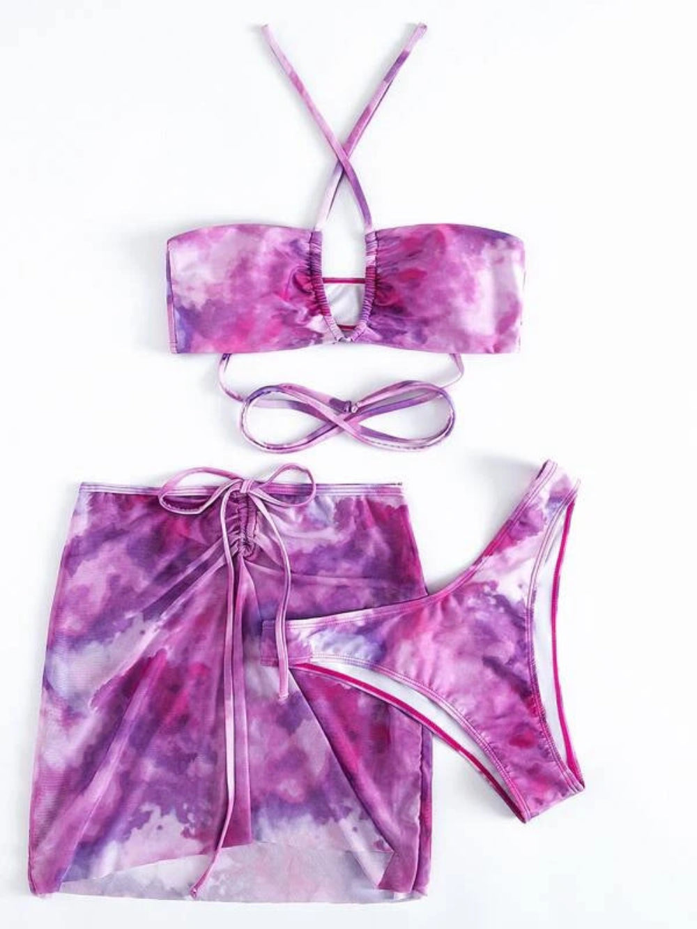 Purple tie-dye three-piece swimwear set with halter bandeau bikini top, matching bikini bottom and ruched mini skirt with tie waist.