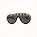Black gold spike crystal shield sunglasses – trendy statement designer sunnies with spikes and rhinestones, studio white background.