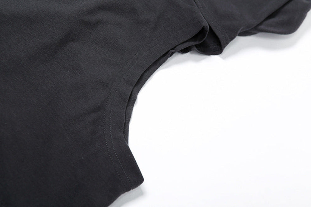 Close-up detail shot of a black garment showing the curved neckline with visible stitching and soft fabric texture against a white background.