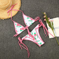 Floral bikini set with matching hat and flowers on a gray surface
