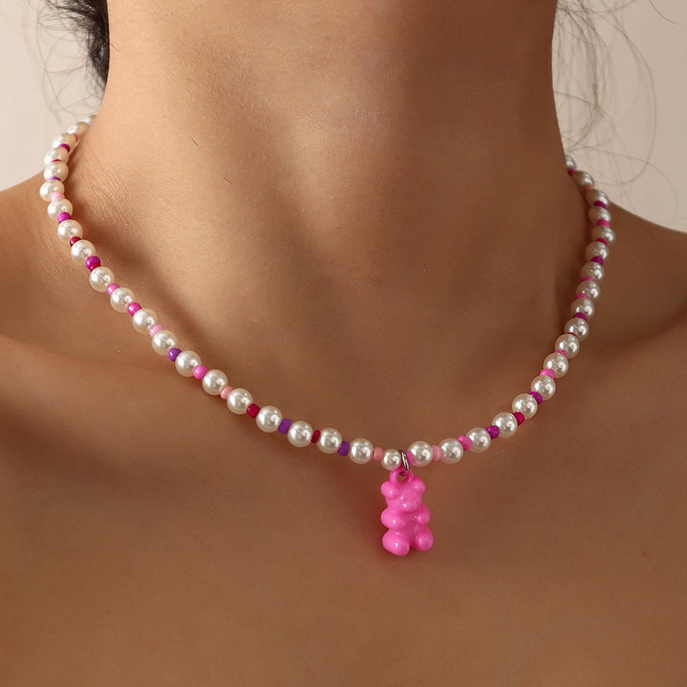 Pink white beaded gummy bear necklace on model – trendy colorful pearl necklace with fun bear pendant, statement jewelry.