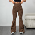 Woman modeling brown leopard print high-waisted flared pants, standing and adjusting the waistband. Paired with a black crop top and sneakers in a bright indoor setting with a gray couch.