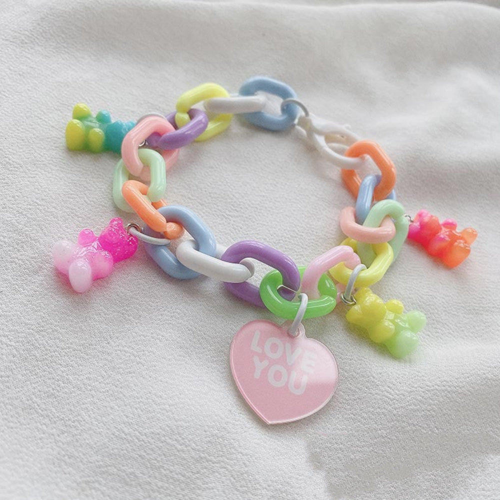 Pastel rainbow chunky chain bracelet with multicolored gummy bear charms and a pink heart charm that says "LOVE YOU"