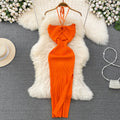 Bright orange ribbed knit halter maxi dress with front keyhole cutout on wooden hanger.