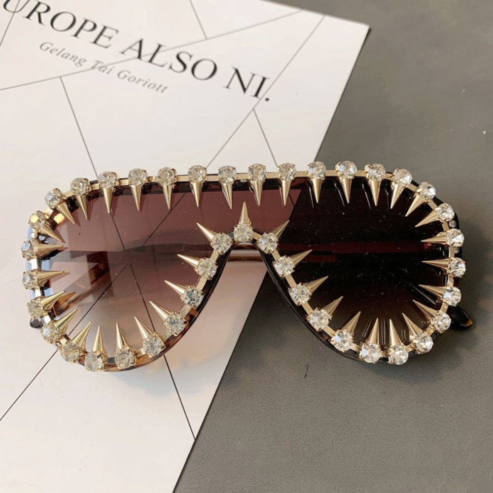 Gold spike crystal sunglasses with dark lenses – trendy designer statement sunnies with spikes and rhinestones, product flat lay.