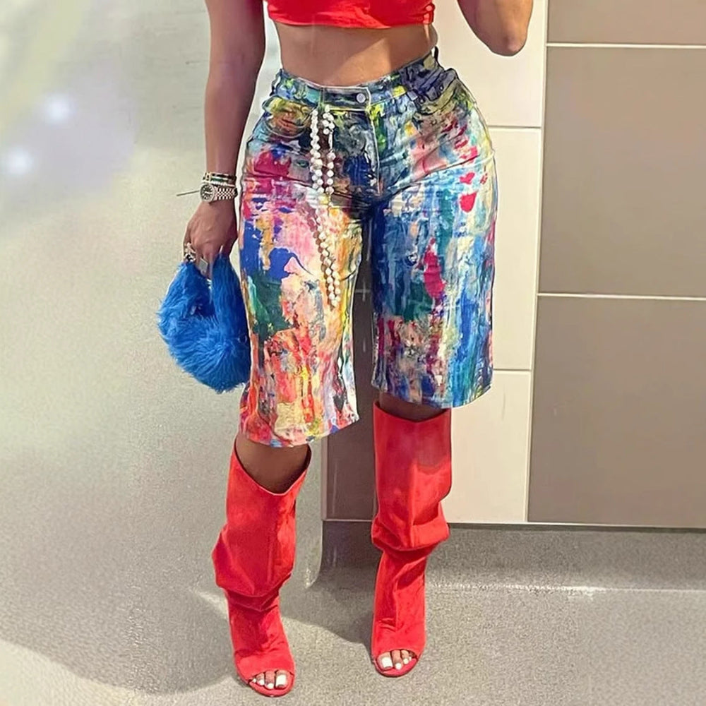 Close-up of vibrant multicolored paint-splatter denim cargo shorts with pearl chain detail, paired with red thigh-high boots and a blue furry handbag. Stylish streetwear fashion look for Boutique Jolie.