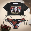 Black crop top and bikini bottom set with skull and rose design on a beige background.