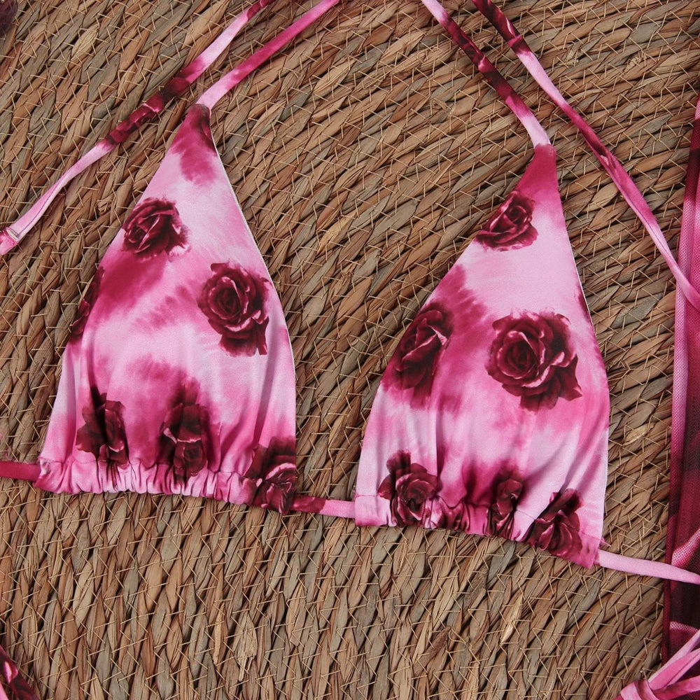 Pink bikini top with floral design on a woven surface