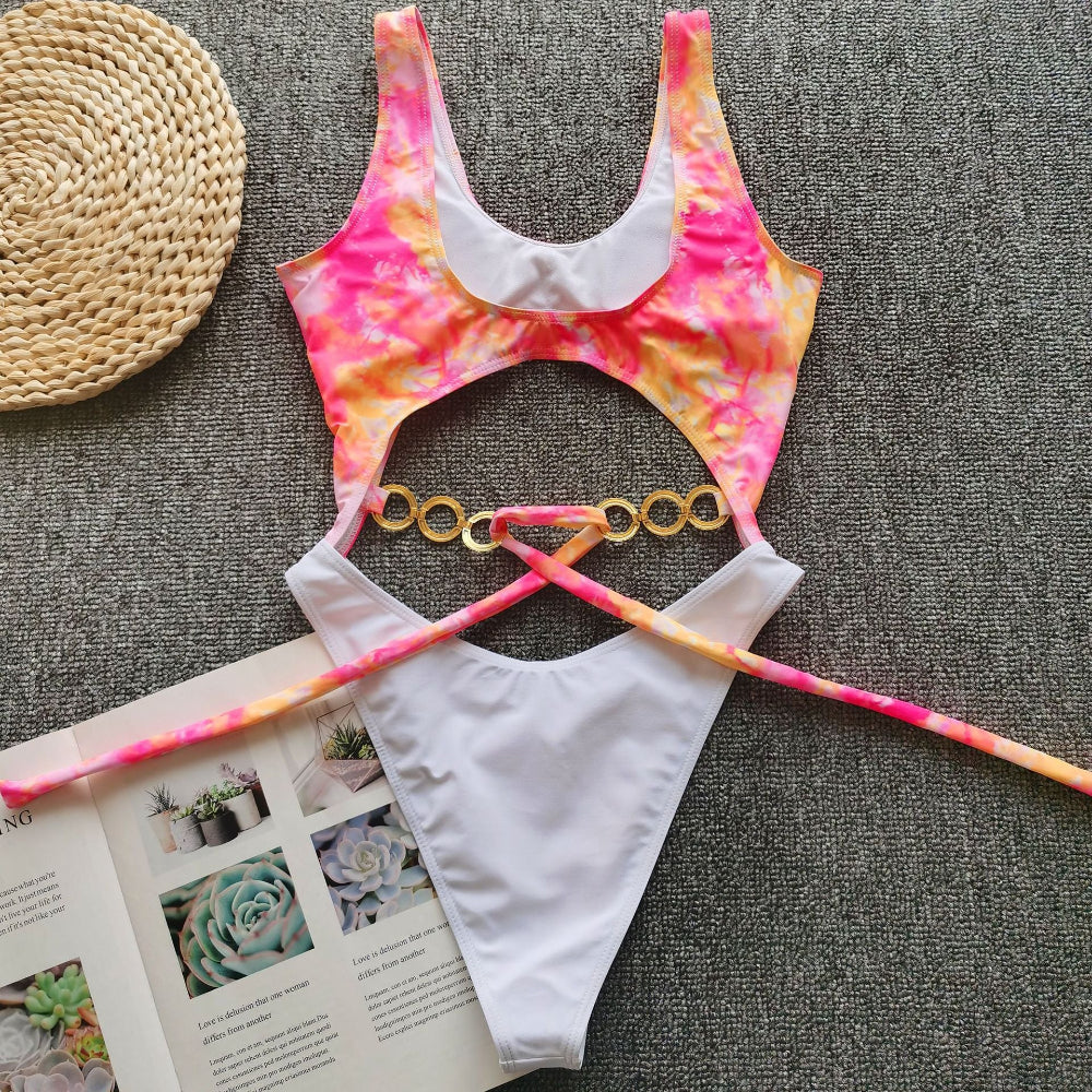 Rainbow tie-dye cutout one-piece swimsuit with gold ring detail and tie waist flat lay