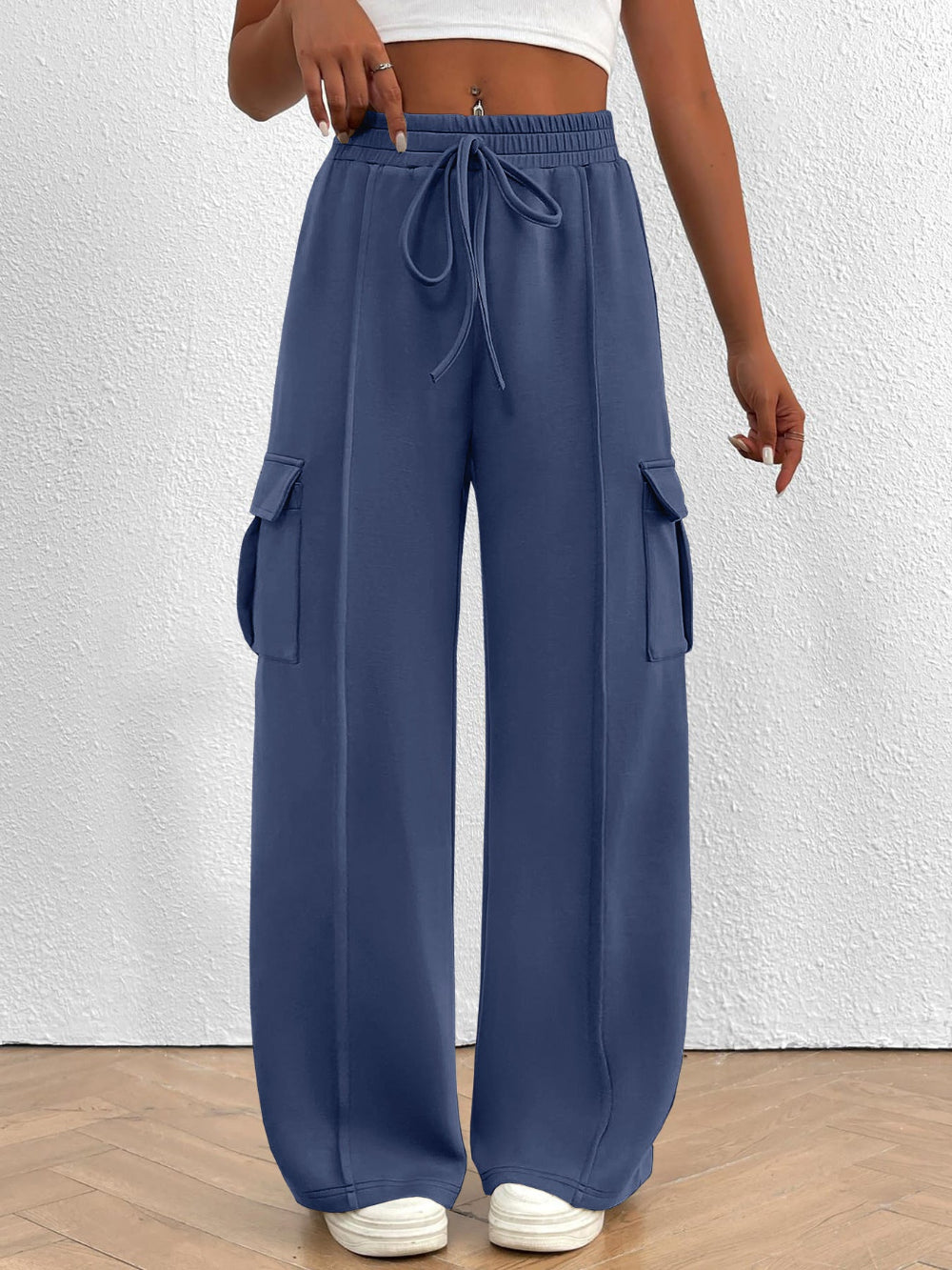 Blue cargo pants worn by a person on a white background
