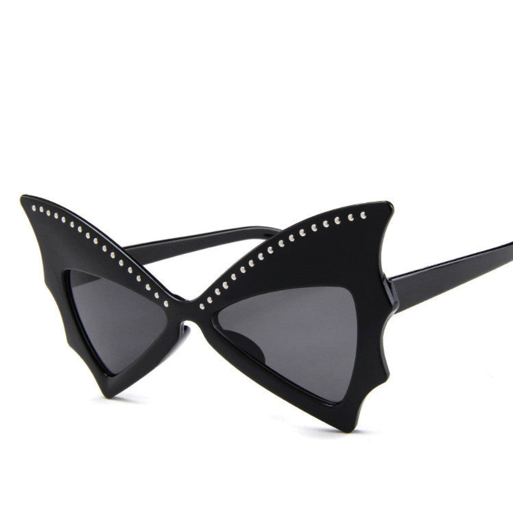 Black batwing sunglasses with rhinestone brow line and dark lenses, product photo on a white background.