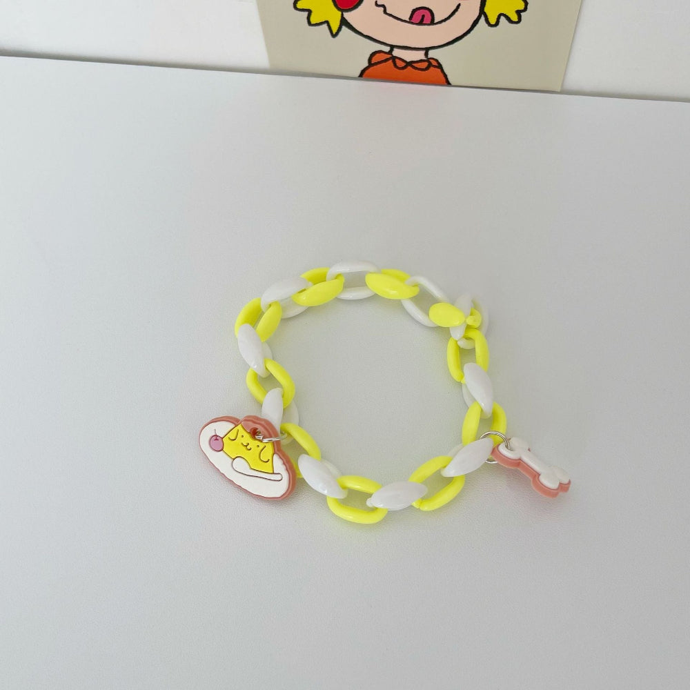 Bright yellow and white link chain bracelet featuring a cute yellow high-top sneaker charm and a pink bone-shaped charm