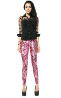 Woman modeling a black sheer long-sleeve button-up shirt with polka-dot sleeves paired with pink leopard print high-waisted leggings and black high heels, full-body pose against a clean white studio background.