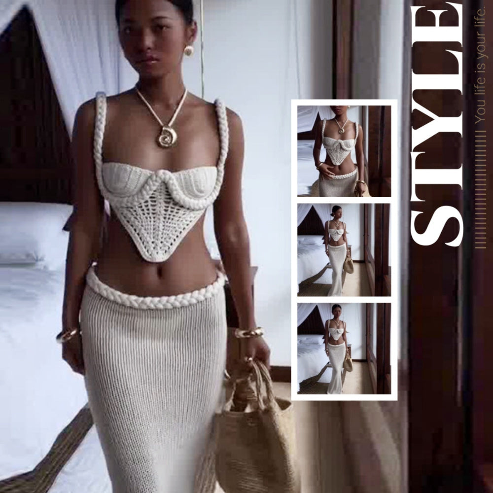 "Model reclining gracefully on an ornate vintage chair wearing an elegant white sparkly strapless jumpsuit with oversized puff sleeves and flowing sash detail."