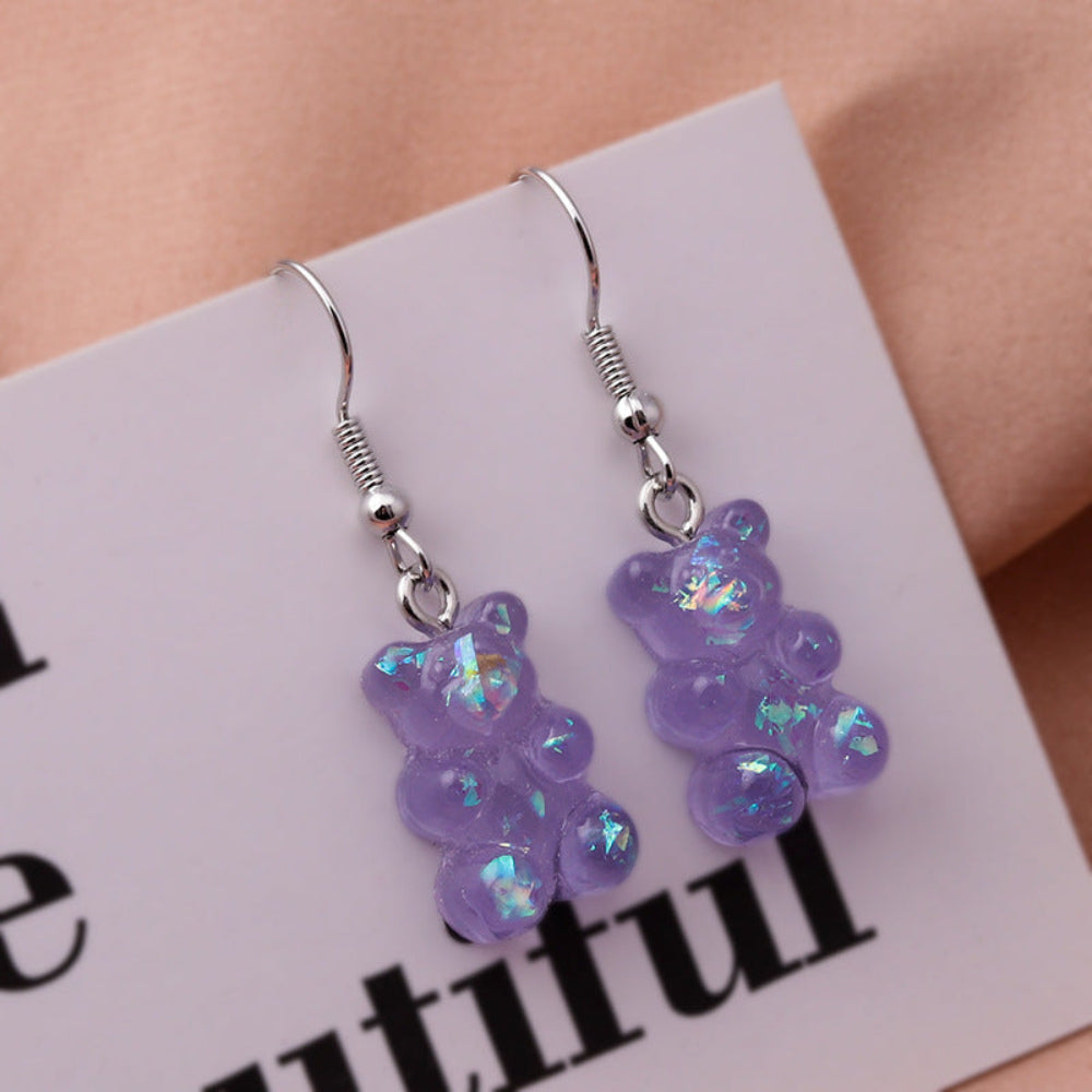 Translucent purple holographic gummy bear earrings with shimmering iridescent sparkle and silver fishhook ear wires
SEO-friendly: