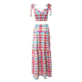 Colorful pastel checkered outfit consisting of a cropped sleeveless top with shoulder ties and a flowy tiered maxi skirt with matching pattern. Flat-lay style product shot on a plain white background, highlighting the vibrant multicolored plaid design and ruffled details.