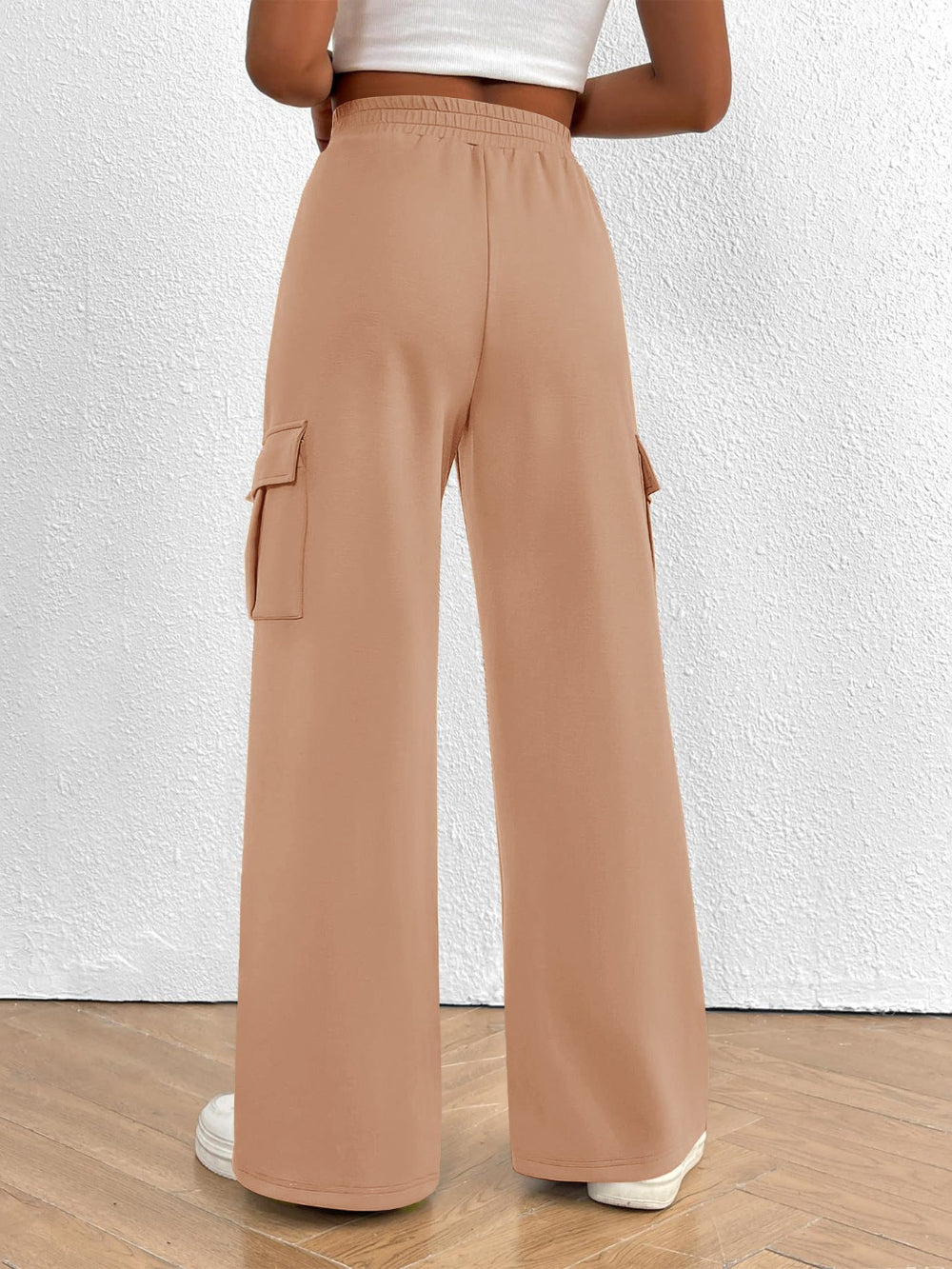 Person wearing tan cargo pants on a white background
