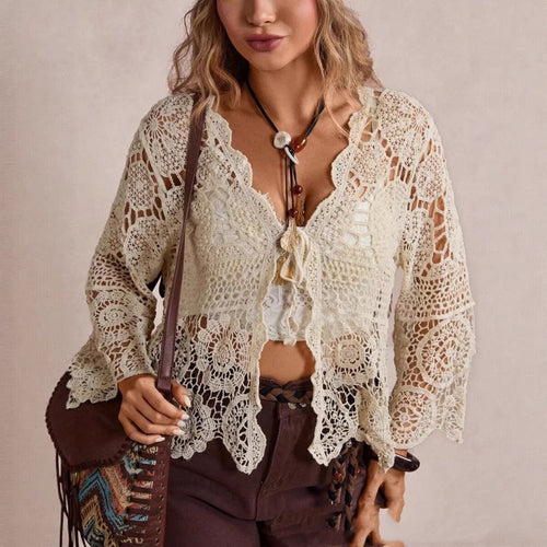 Cream crochet lace cardigan with scalloped hem and tie front, shown on a model.