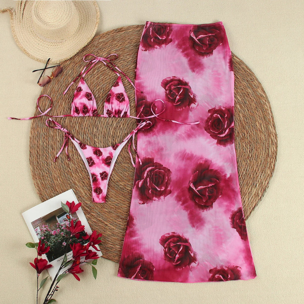 Pink tie-dye bikini set with matching scarf on a woven mat.