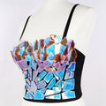 Mannequin wearing a striking iridescent mosaic crop top with shattered mirror fragments in holographic blue, purple, and copper tones on a black base. Features thin black shoulder straps and a bold, reflective fragmented design.