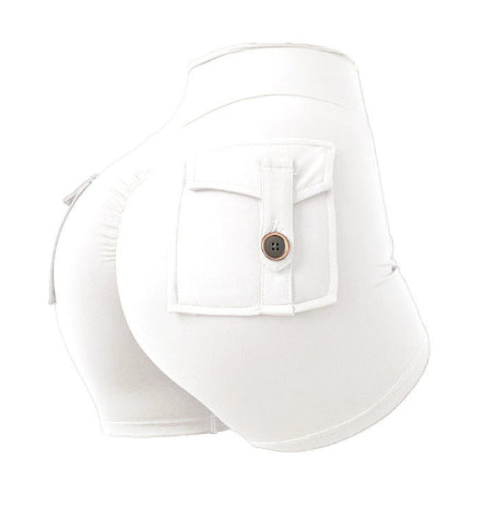 Woman modeling white high-waisted athletic cargo shorts with a large flap pocket and button detail, shown from a rear three-quarter view against a clean white studio background.