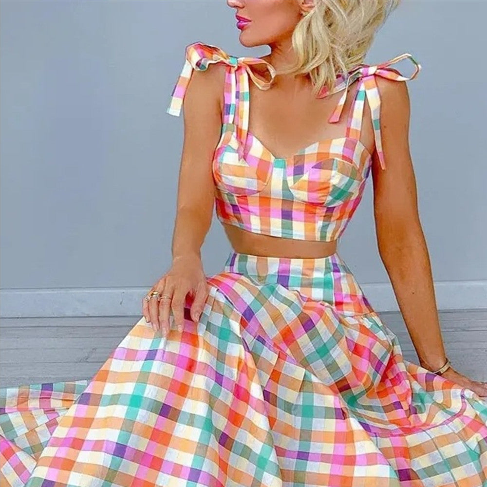 Woman wearing a colorful plaid dress with a gray background