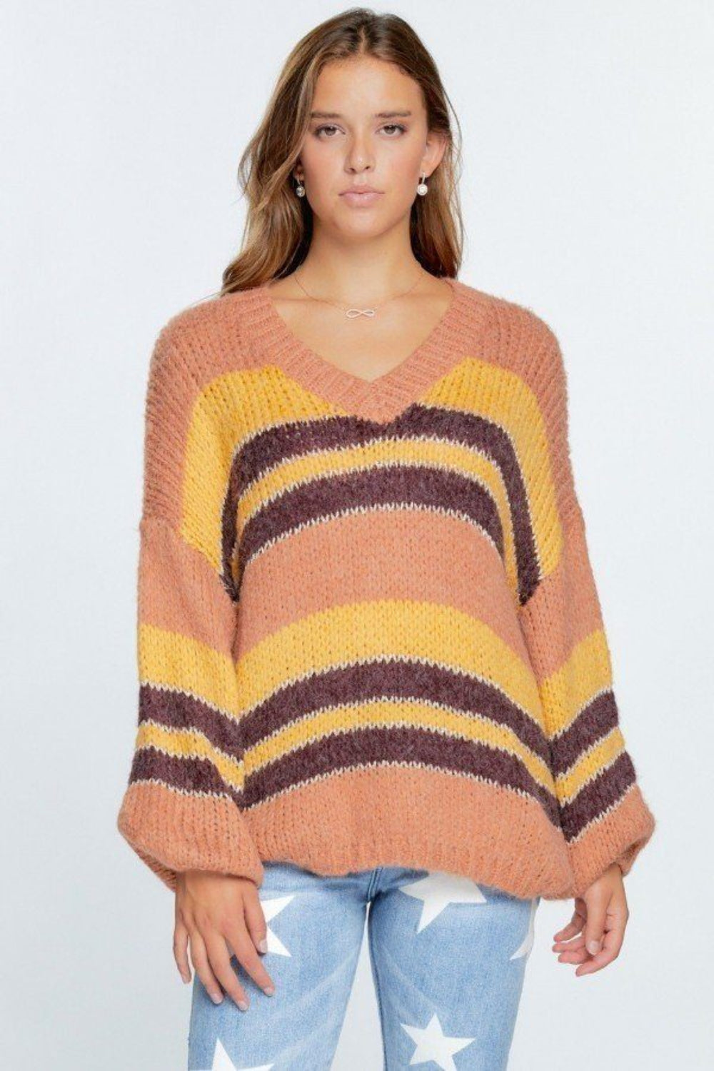 Woman wearing a striped sweater with a plain background