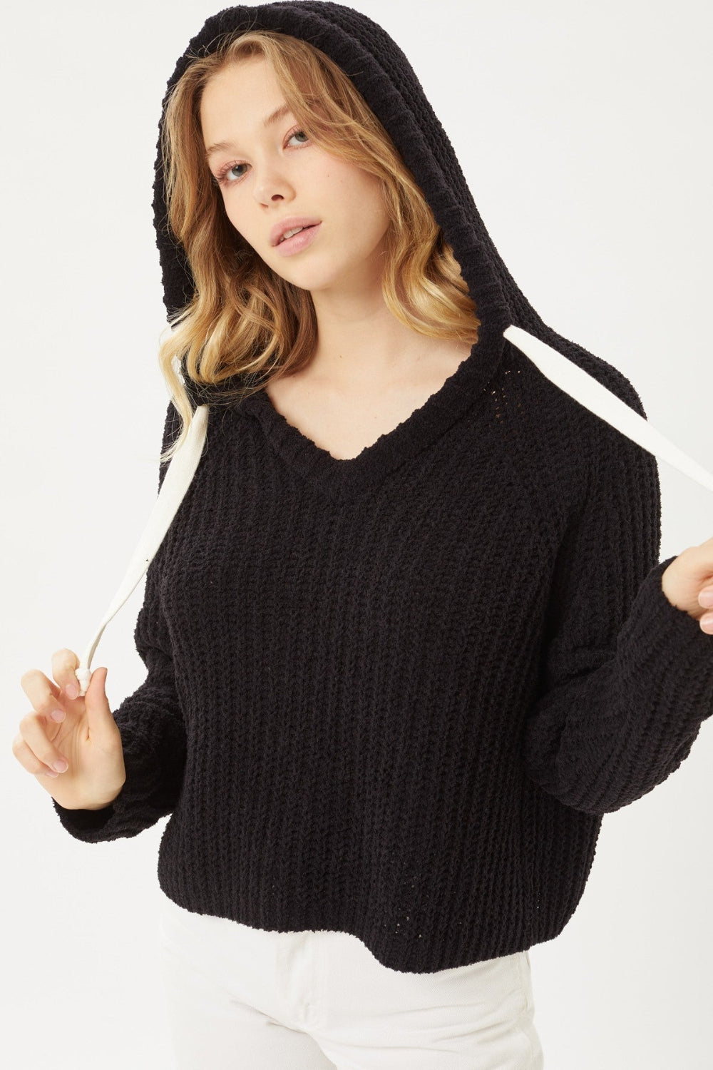 Woman wearing a black hoodie with white accents on a white background