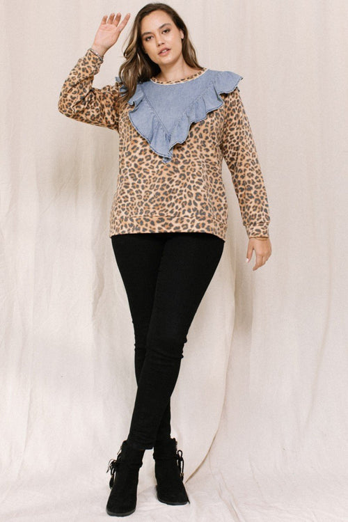 Woman wearing a leopard print top with a denim ruffled collar against a plain background