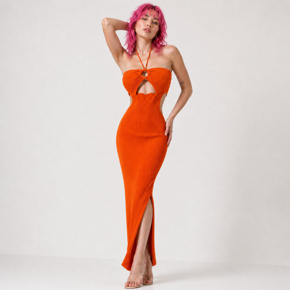 Model with pink hair wearing vibrant orange ribbed knit halter maxi dress with front keyhole cutout and side slit.