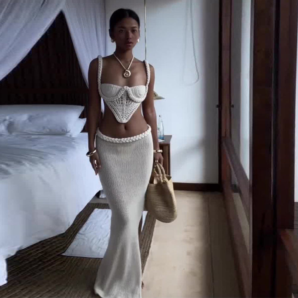 "Elegant white knitted co-ord set consisting of a textured crochet square-collar camisole top and a matching figure-hugging ribbed maxi skirt, styled with gold accessories and a straw bag."