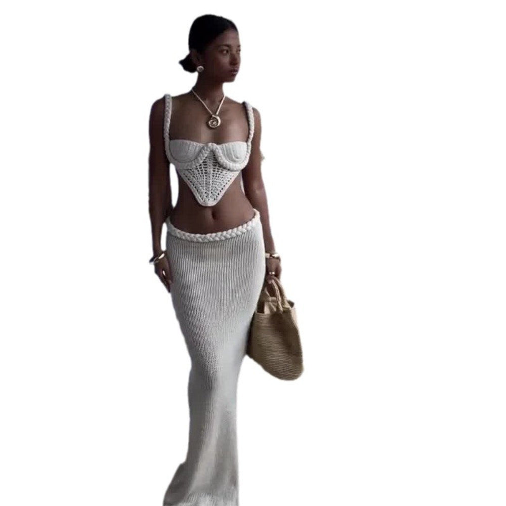 "Model standing elegantly in a luxurious bedroom wearing a white strapless jumpsuit featuring sheer embellished fabric, voluminous satin puff sleeves, and a long sash."