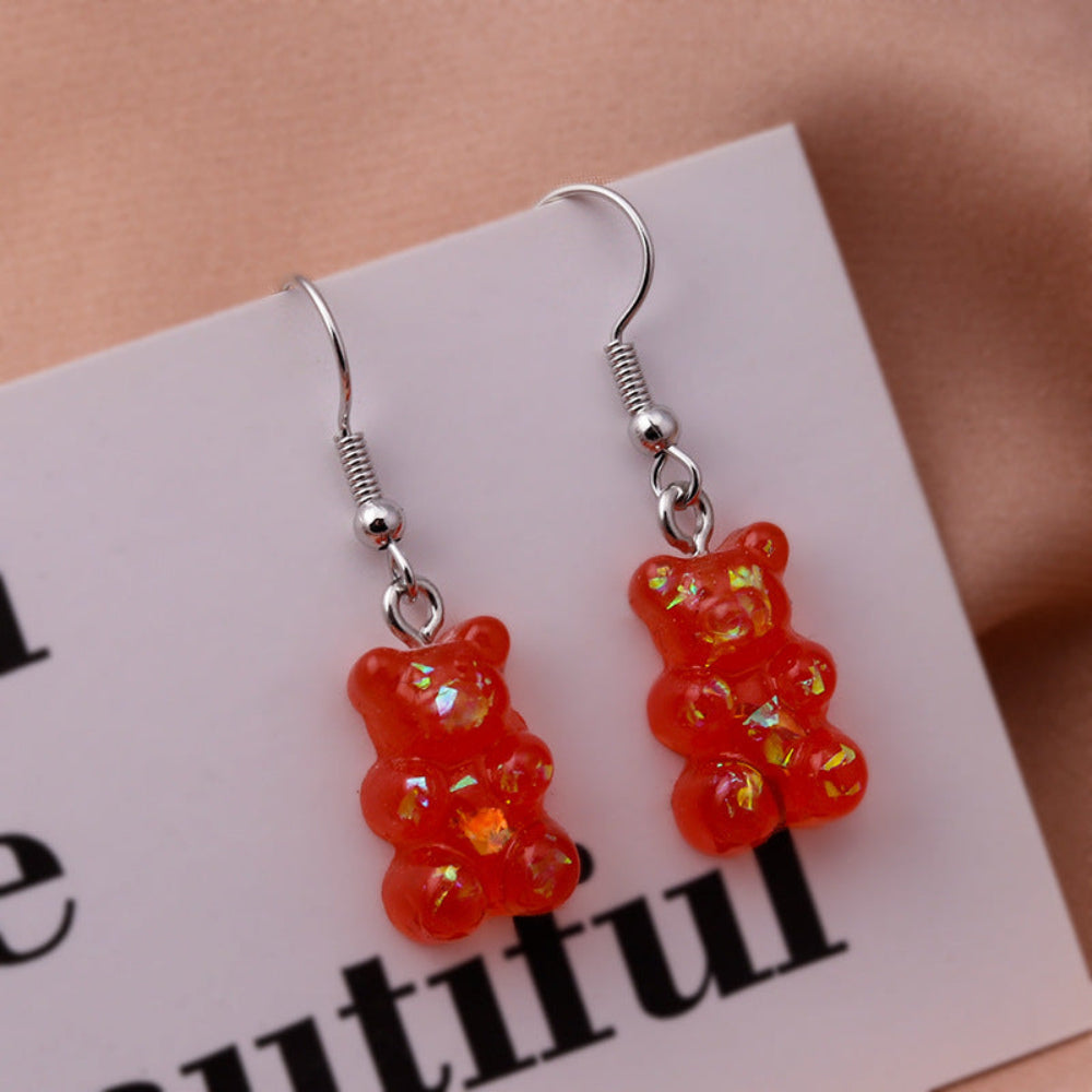 Translucent red holographic gummy bear earrings with shimmering iridescent sparkle and silver fishhook ear wires