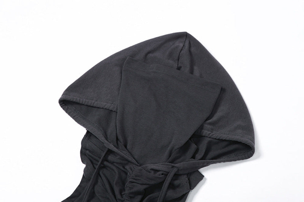 Close-up detail of the black hooded crop top showing the structured hood with face opening, gathered and ruched fabric construction, and long adjustable ties.