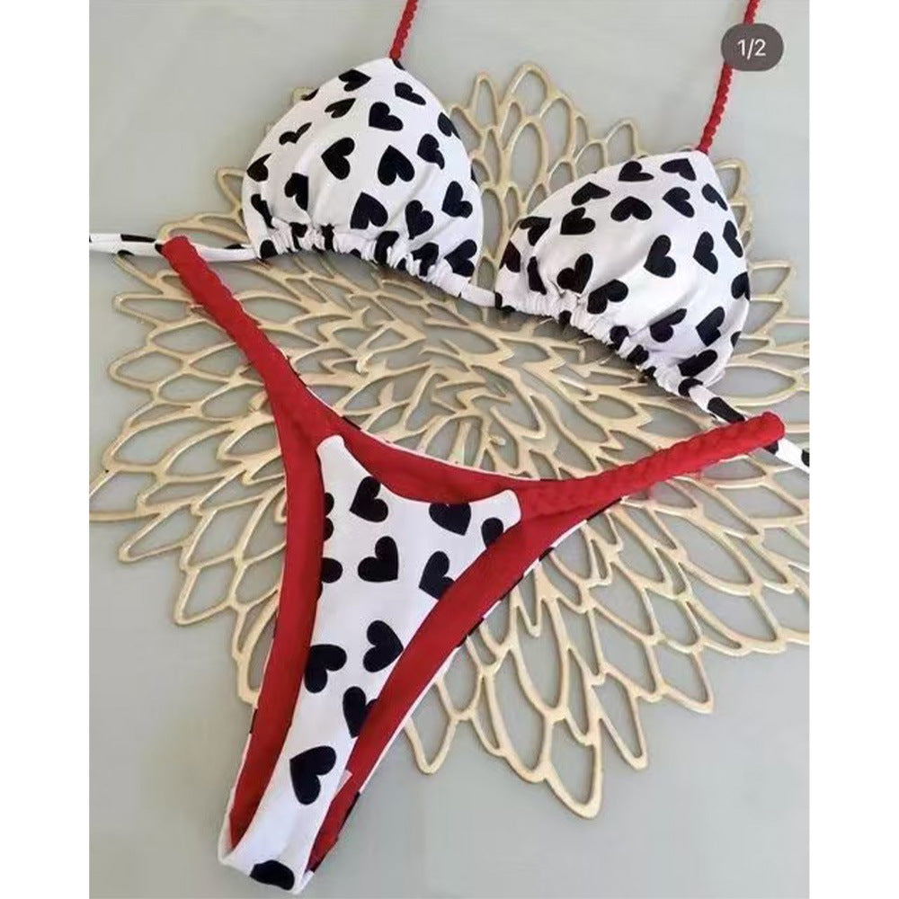 Bikini set with black heart pattern on white top and red bottom on a decorative gold background