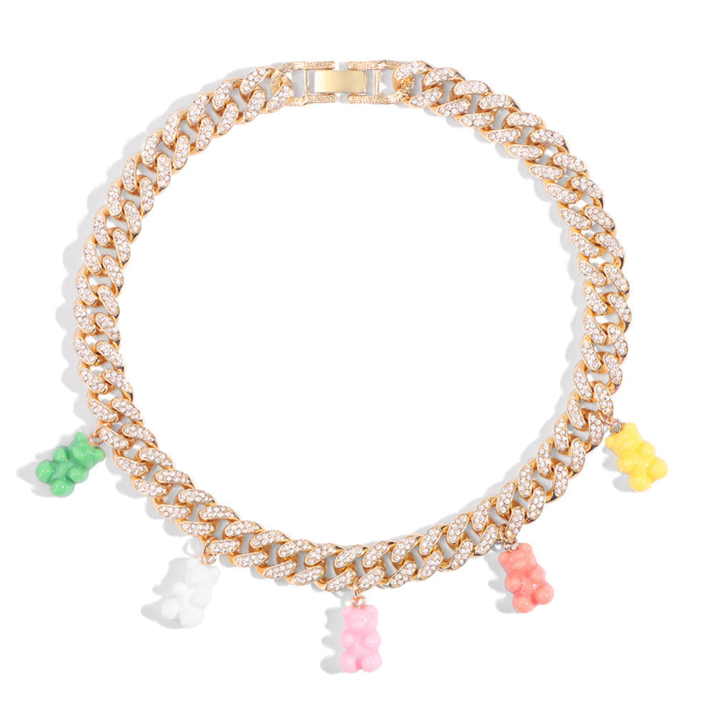 Gold Cuban link choker necklace fully iced with sparkling cubic zirconia stones, adorned with colorful gummy bear charms in green, white, pink, orange, and yellow. Bold luxury statement piece.