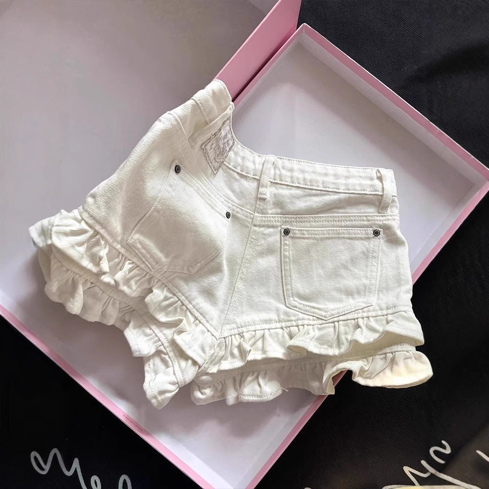 Back view of cream-colored denim shorts with adorable multi-tiered ruffled hems, back pockets, and embroidered Sugarwish label, neatly displayed inside a pink gift box. Cute feminine fashion shorts for Boutique Jolie.