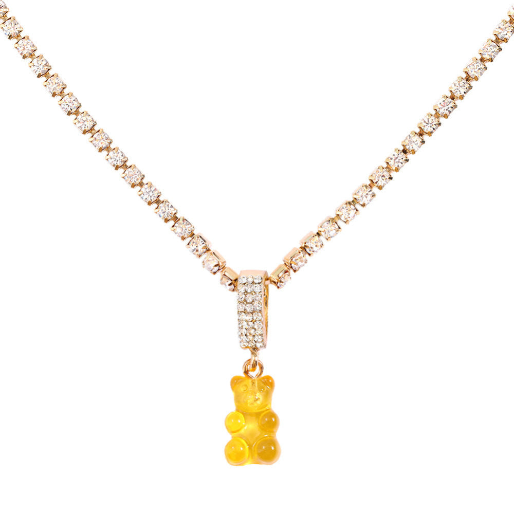 Sparkling silver tennis chain necklace featuring a fully pavé-style band and a bright orange translucent gummy bear pendant hanging from the center. Clean product photography on a plain white background.