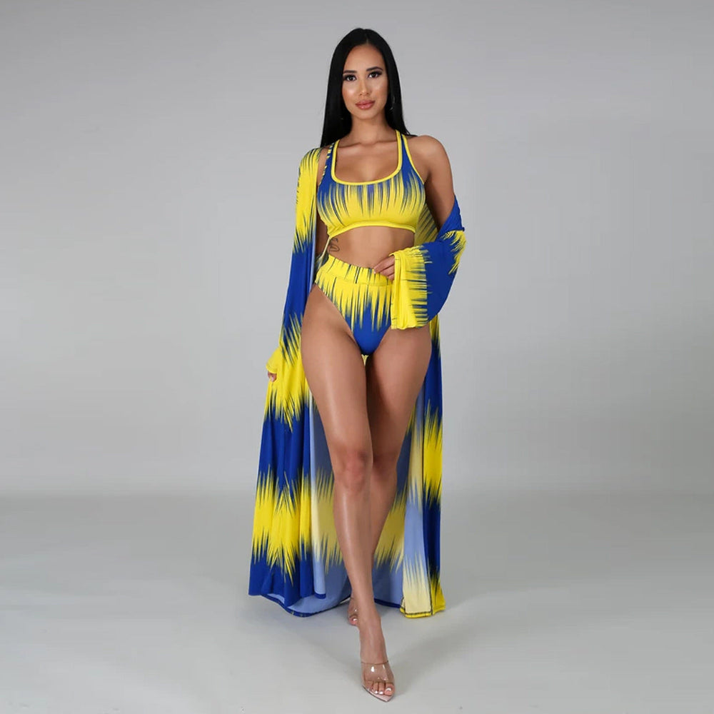 Woman wearing a blue and yellow bikini with matching cover-up on a gray background