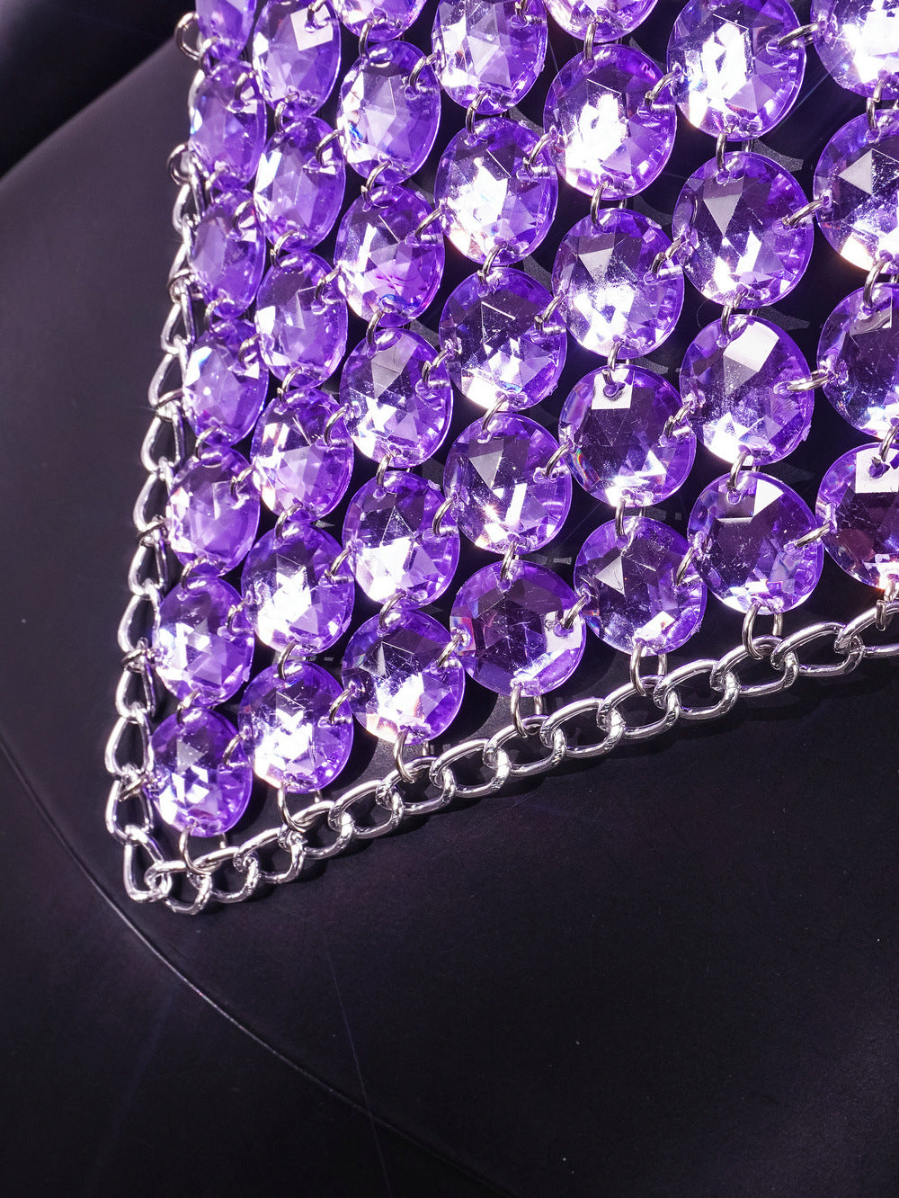 Purple rhinestone halter top with diamond-shaped crystal embellishment and chain trim, close-up detail view.