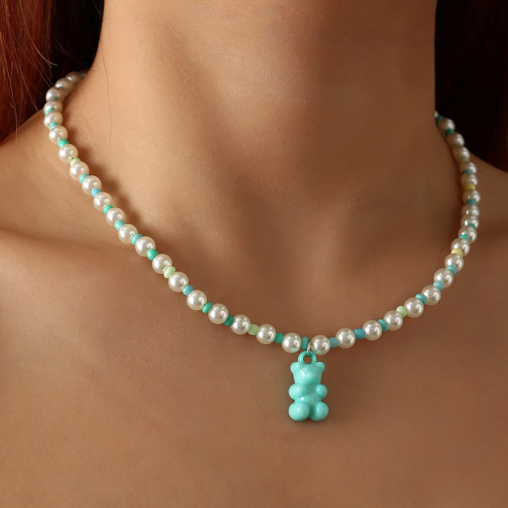 White sky blue pearl gummy bear necklace on model – trendy colorful beaded choker with fun bear pendant, statement jewelry.