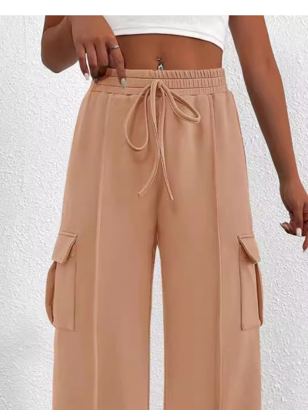 Tan cargo pants with a drawstring on a white background