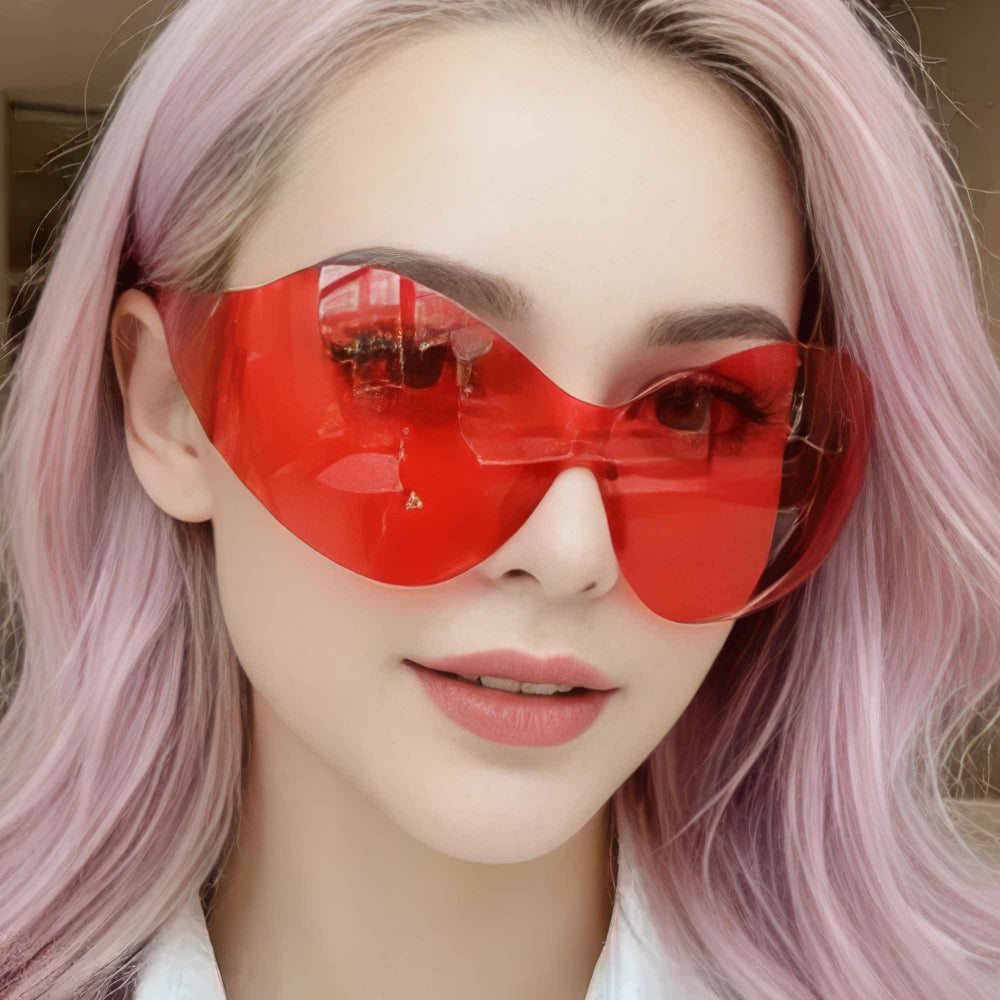 "Woman with pink hair wearing bold red oversized sunglasses with butterfly-inspired frame"